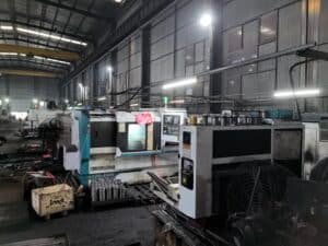 CNC machining center in a factory workshop producing precision metal components and bearings for industrial die cutting machines.