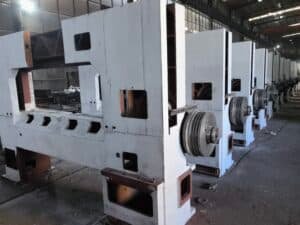 Heavy-duty cast iron frames and flywheels of industrial paper cutters during manufacturing, ensuring stability to reduce vibration and blade deflection.