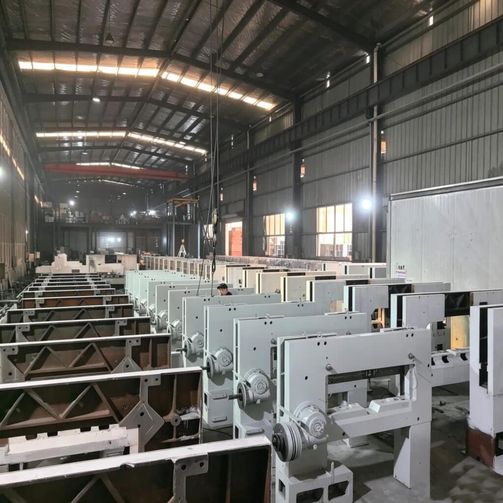 Industrial paper cutting machine frames being assembled in a factory, highlighting the robust internal structure and manufacturing quality