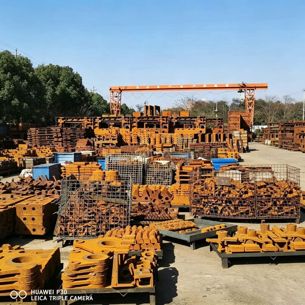 Large inventory of raw castings and structural parts for paper cutting machines, indicating large-scale manufacturing capability