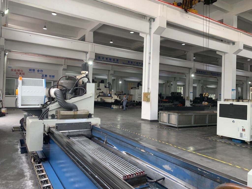 A large industrial CNC knife grinding machine in a factory workshop, showcasing its rigid structure and precision guide rails for stable grinding performance.