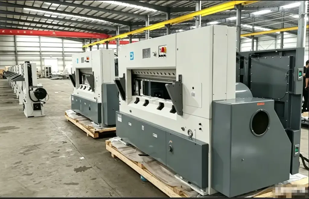 Finished automated paper cutting machines ready for shipment on wooden pallets, illustrating final-stage quality inspection and logistics preparation in smart factories.