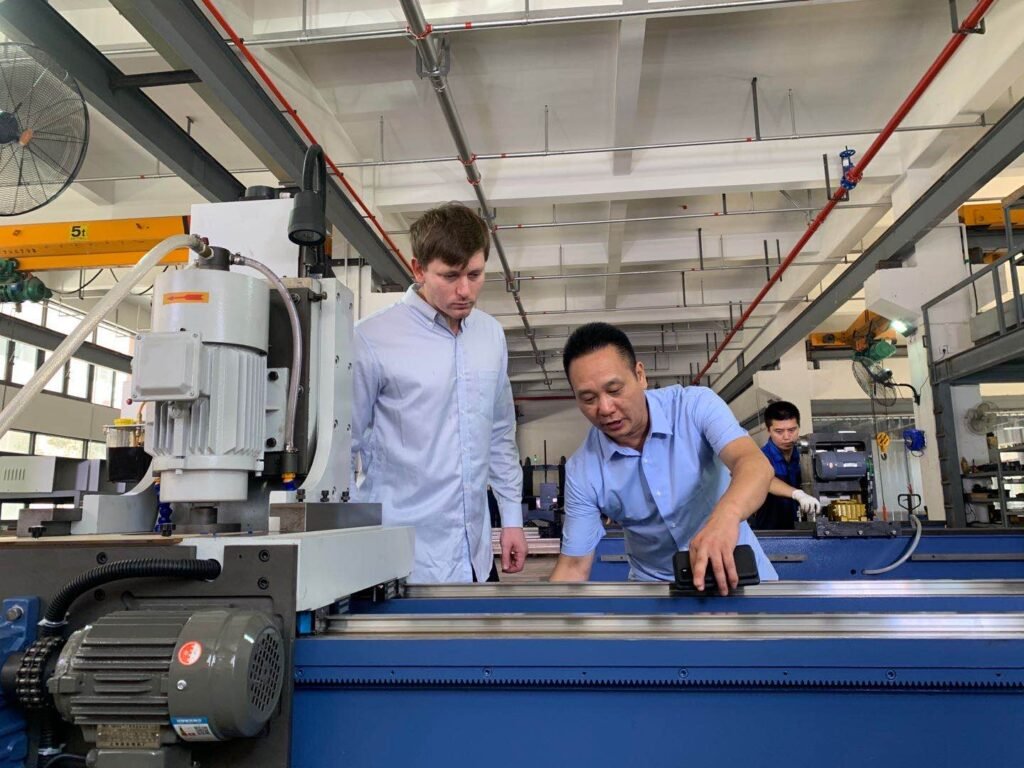 Two engineers inspecting the guide rail of a knife grinding machine, emphasizing the importance of precision components and machine setup for optimal grinding accuracy.