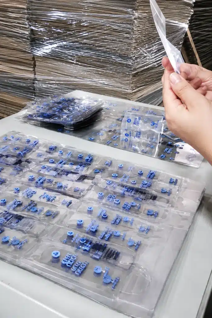 Custom thermoformed plastic tray holding small electronic components, demonstrating precision die-cutting for industrial packaging