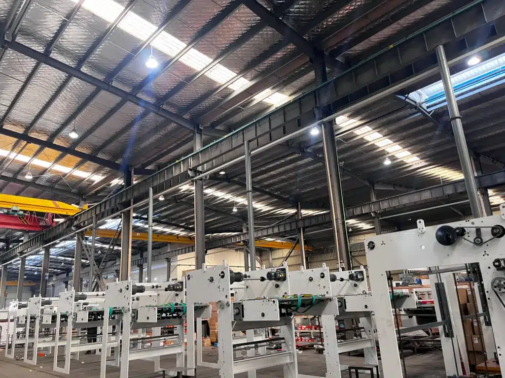 Wide-angle view of a modern die cutting workshop with multiple machine frames and overhead cranes.