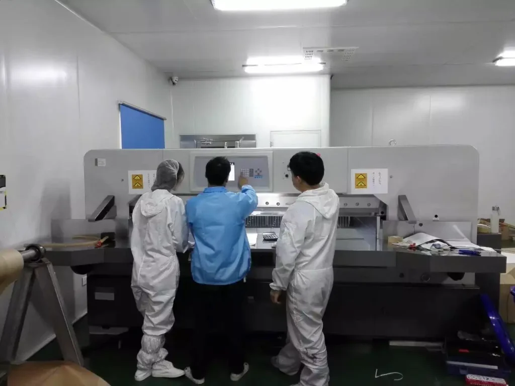 Operators receiving hands-on training on paper cutting machine controls and safety procedures.