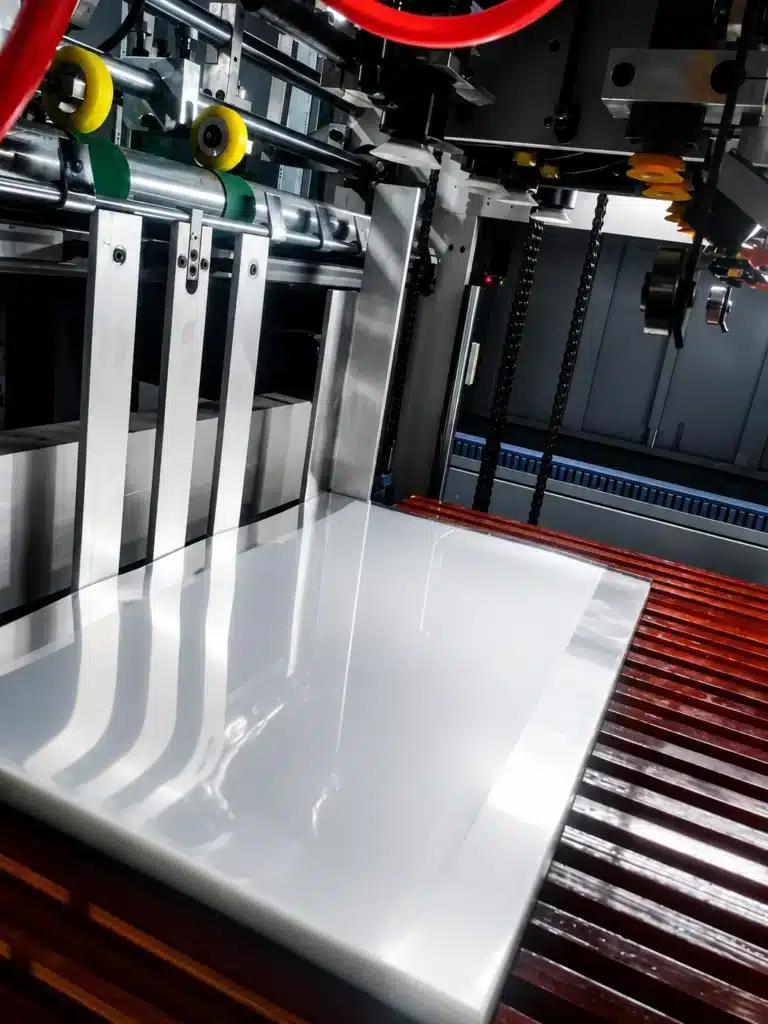High-speed die cutting machine processing glossy paperboard sheet for precision packaging
