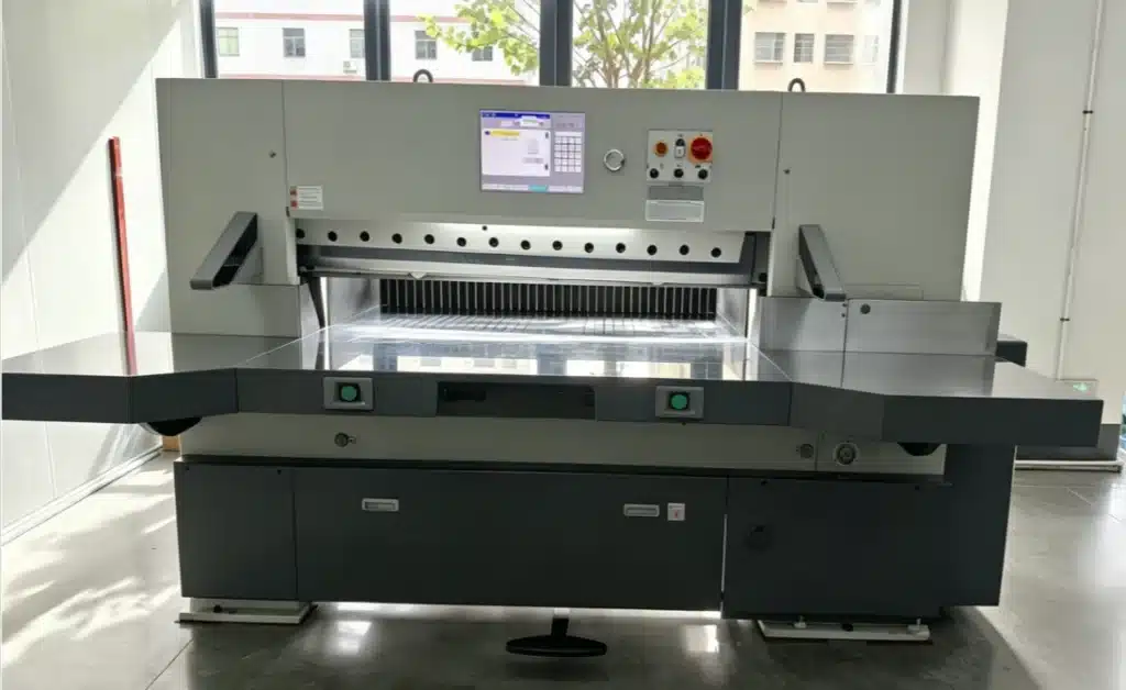 Front view of servo-driven high-speed paper cutting machine with dual safety buttons and digital display for precision packaging cuts