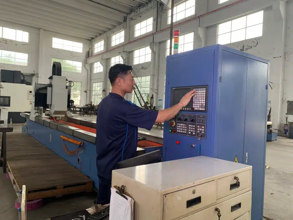Engineer operating industrial knife sharpening machine in manufacturing workshop